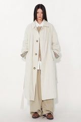 Waist-cinched, straight-cut, with a plaid patchwork design and raglan sleeves, this trench coat features a bold silhouette.