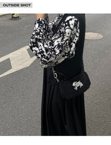 Betweenand "The original Dalmatian underarm satchel is a small black bag that people can't put down"