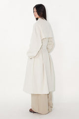 Waist-cinched, straight-cut, with a plaid patchwork design and raglan sleeves, this trench coat features a bold silhouette.