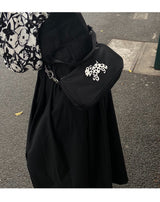 Betweenand "The original Dalmatian underarm satchel is a small black bag that people can't put down"