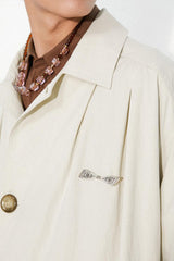 Waist-cinched, straight-cut, with a plaid patchwork design and raglan sleeves, this trench coat features a bold silhouette.